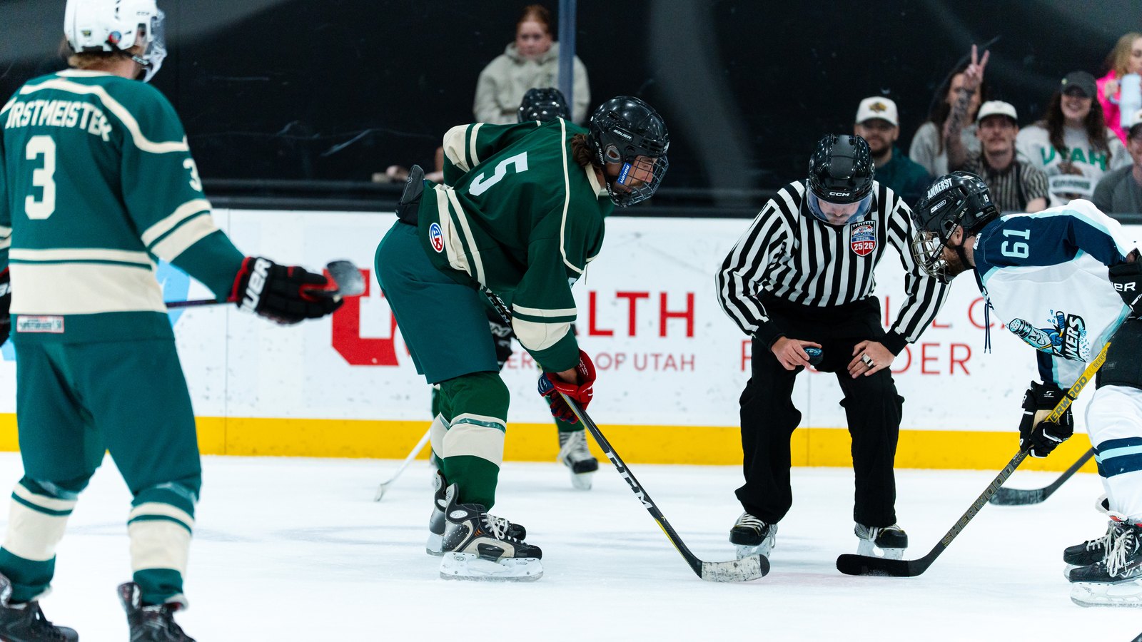 Beer league hockey players lined up for a faceoff in full gear