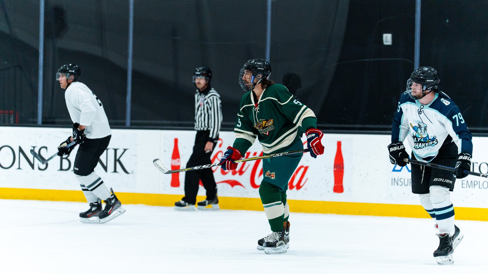 Two beer league hockey teams lined up in jerseys on Utah ice
